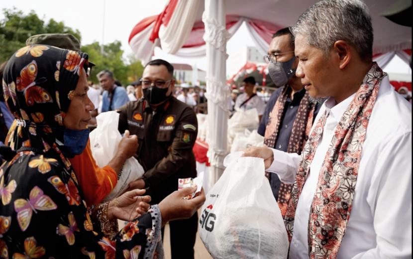 SVP of Supporting SIG, Muchamad Supriyadi (kanan), menyerahkan paket sembako murah secara simbolis kepada warga Rembang pada acara Pasar Murah dan Bazar UMKM BUMN di Alun-Alun Kabupaten Rembang, Jawa Tengah, Kamis (21/7).