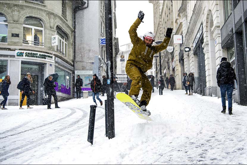Sylvain berselancar di atas papan ski nya di jalanan yang tertutup salju di Lausanne, Switzerland..