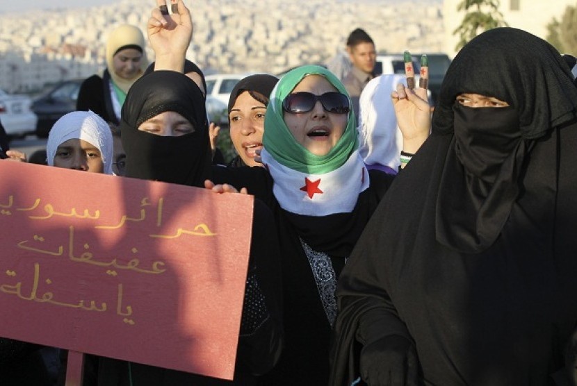 Syrian protesters living in Jordan shout slogans against Syria's President Bashar Al-Assad during a protest outside the Syrian embassy in Amman June 28, 2012. The placard reads 