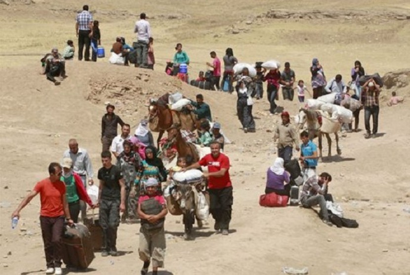 Syrian refugees cross into Iraq at the Peshkhabour border point in Dahuk, 260 miles (430 kilometers) northwest of Baghdad, Iraq, Tuesday, Aug. 20, 2013. Around 30,000 Syrians, the vast majority of them Kurds, have fled the region over a five-day stretch an
