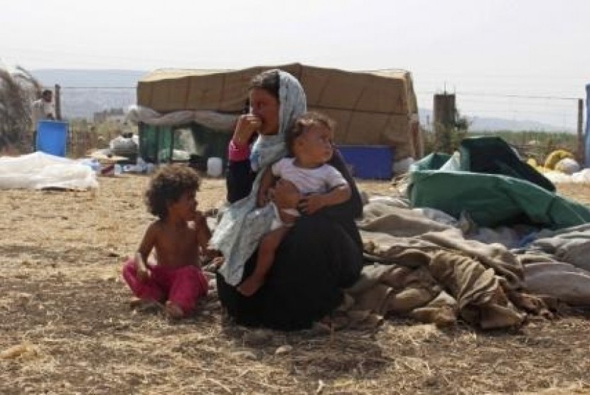 Syrian refugees rest with their belongings in Halba, Lebanon, September 24, 2014. 