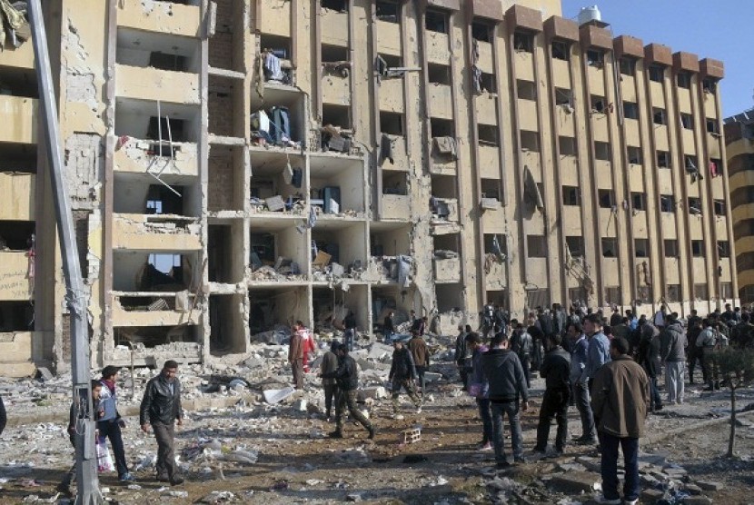 Syrian security personnel and civilians gather at the site where two explosions rocked the University of Aleppo in Syria's second largest city, January 15, 2013.  