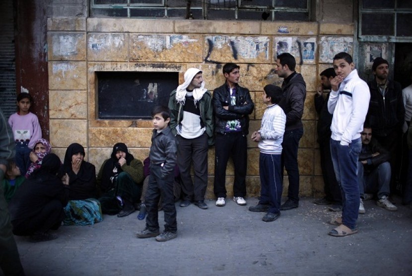 Syrians wait outside a bakery in Aleppo city December 27, 2012. Syria's 21-month-old conflict has killed 44,000 people.   