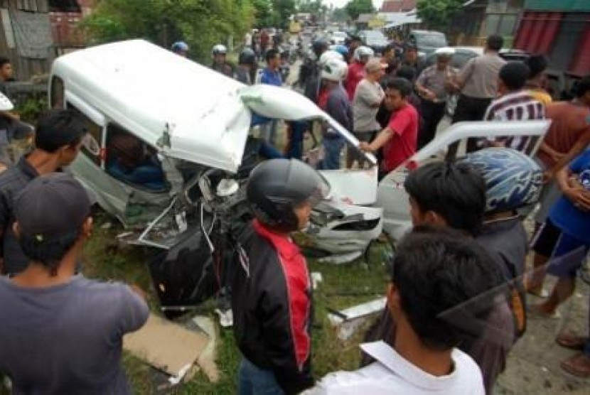 TABRAKAN ANGKOT VS TRAVEL. Sejumlah warga melihat angkot yang hancur akibat bertabrakan dengan minibus travel, di Jalan Raya Padang - Bukittinggi, kawasan Pasar Usang, Kec. Batang Anai, Kab. Padangpariaman, Sumbar, Selasa (15/1).