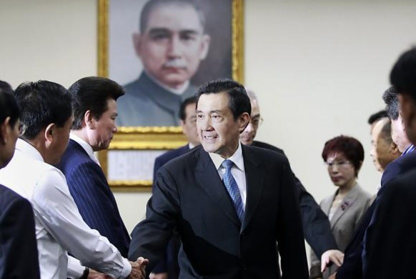 Taiwan President Ma Ying-jeou (center) shakes hands with Kuomintang (KMT) party officials after announcing his resignation from the party's chairman position during their central standing committee in Taipei December 3, 2014.