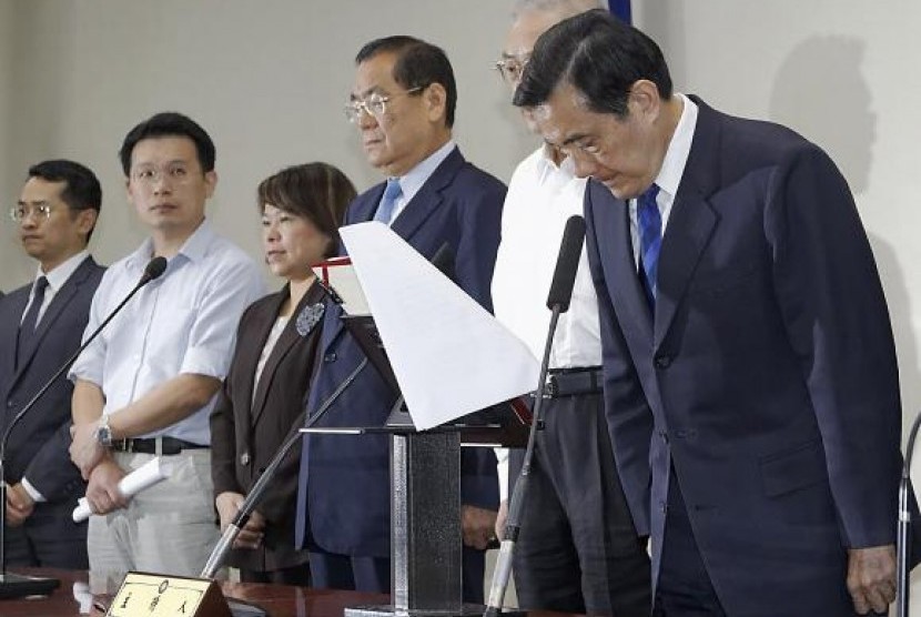 Taiwan President Ma Ying-jeou (R) bows during a news conference with party officials after the ruling Kuomintang (KMT) party was defeated in the local elections in Taipei November 29, 2014. 