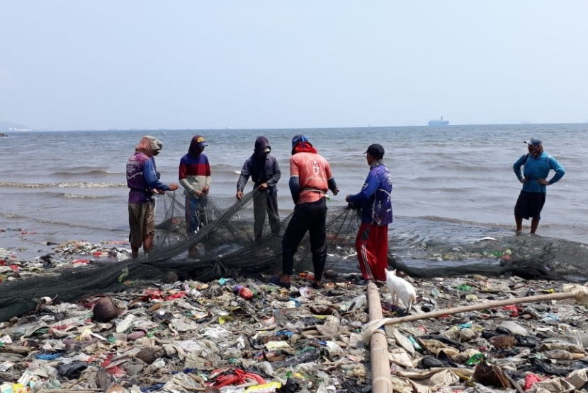 Tampak nelayan di wilayah Sukaraja, Bandar Lampung sedang berada diatas tumpukan sampah di tepi pantai