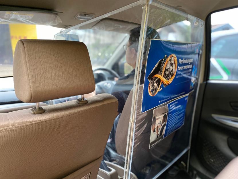 Tampak partisi plastik yang memisahkan pengemudi dengan penumpang pada taksi Grab