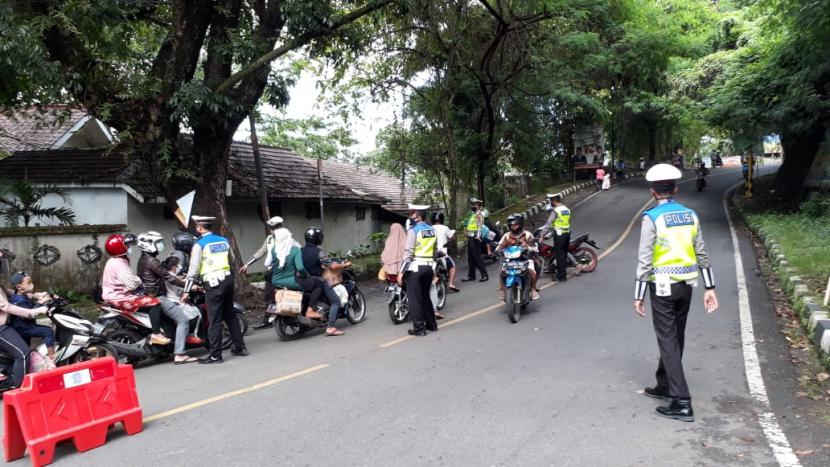 Tampak petugas kepolisian di Sukabumi meminta sejumlah pengendara motor untuk putar balik  guna menekan angka penyebaran Covid-19