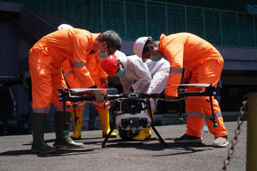Tampak petugas sedang menyiapkan drone yang digunakan untuk penyemprotan disinfektan