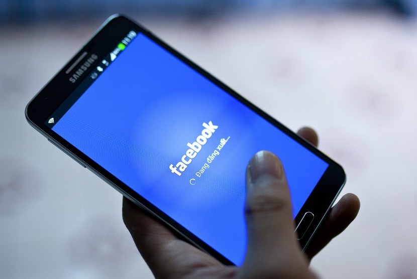 Tampak seorang pria sedang mengakses laman sosial media, Facebook.