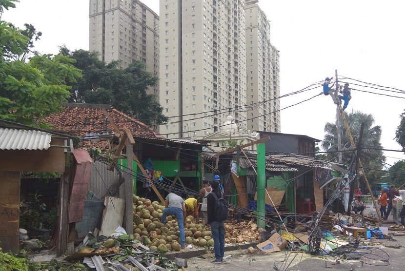 Tampak warga sedang membersihkan reruntuhan bangunan kios yang hancur 