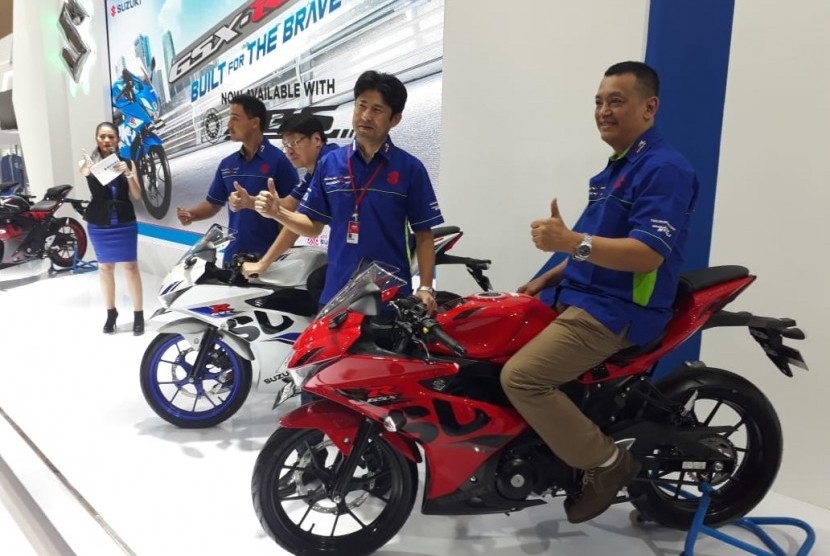 Tampak Yuhan Yahya (paling kanan) sedang duduk diatas Suzuki GSX-R150 ABS warna merah usai pembukaan IMOS 2018, Rabu (31/10)