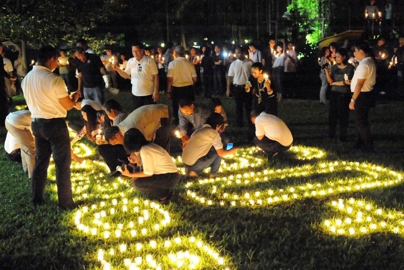 Tamu dan karyawan menyalakan lilin dalam ajang Earth Hour di Hotel Borobudur Jakarta.