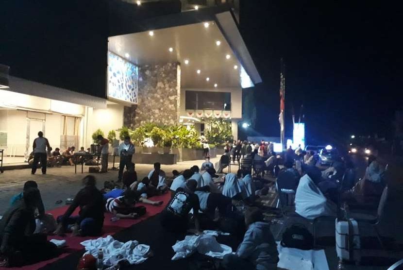 Tamu yang berada di salah satu hotel di Mataram diberikan karpet dan selimut di luar hotel pascagempa pada Ahad (19/8) malam. 