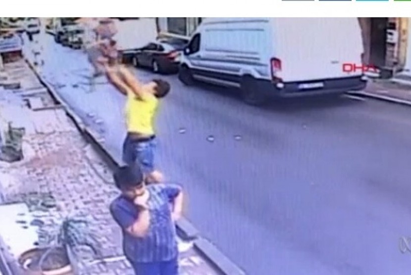 Tangkapan layar CCTV pemuda yang menangkap anak balita terjatuh dari apartemen.