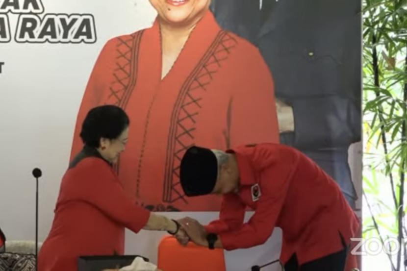 Tangkapan layar Ketua Umum PDIP Megawati memberikan peci hitam kepada Ganjar Pranowo sebagai simbol deklarasi Capres PDIP di Istana Batu Tulis Bogor, Jawa Barat, Jumat (23/4/2023).