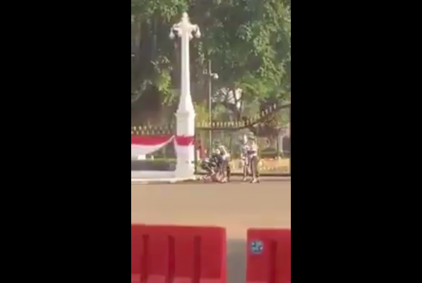 Tangkapan layar (screen capture) dari video yang menunjukkan petugas menghalau pria bugil masuk ke Istana. Video yang beredar di media sosial ini mengundang reaksi netizen. 