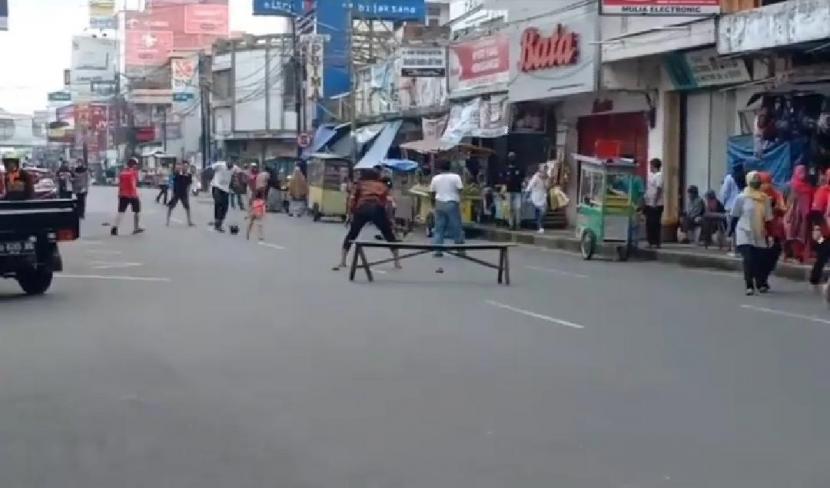 Tangkapan layar video sejumlah warga bermain bola di tengah Jalan HZ Mustofa, Kota Tasikmalaya, pada hari pertama penerapan PSBB, Rabu (6/5). 