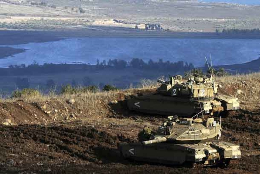 Tank-tank Israel dalam posisi menghadap sebuah desa Suriah dari Dataran Tinggi Golan.