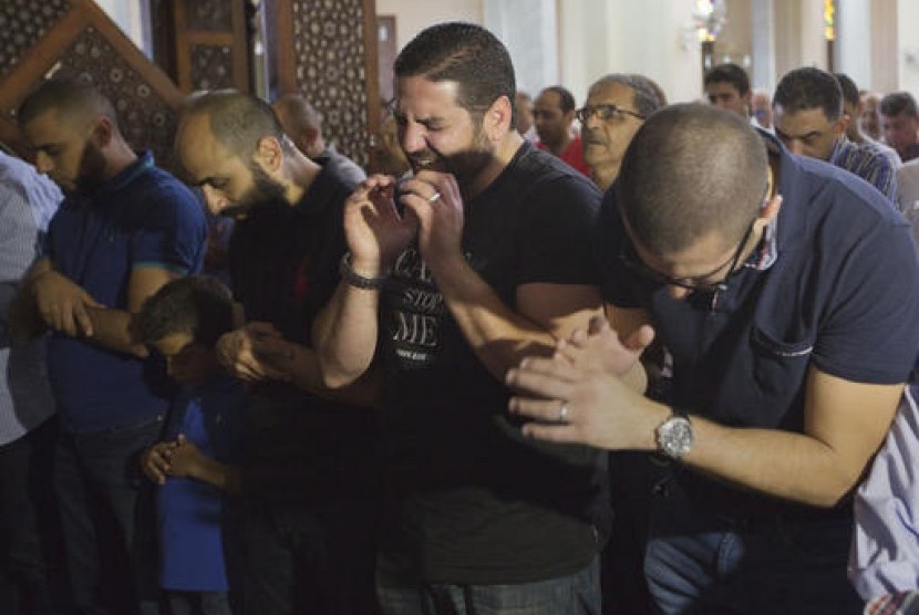 Tarek Abu Laban (tengah) yang kehilangan empat kerabat dalam penerbangan Egypt Air MS804 tak kuasa menahan kesedihannya saat melaksanakan shalat jenazah di Masjid Al Thawrah di Kairo, Mesir, Jumat, 20 Mei 2016.