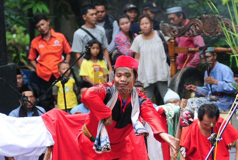 Anggota Kelompok Penyelenggara Pemungutan Suara (KPPS) yang mengenakan busana penari dan pelawak Bali membantu pemilih saat pemungutan suara Pilkada Serentak di Desa Penarungan, Kabupaten Badung, Bali, Rabu (9/12). 