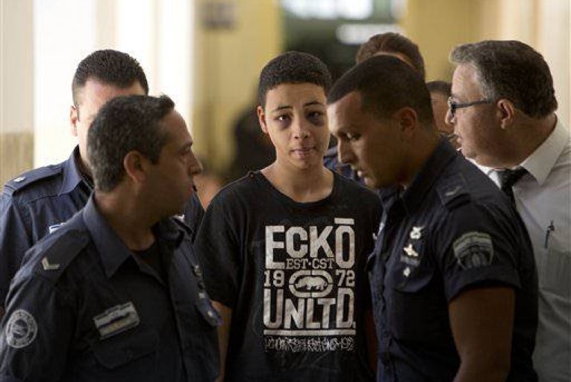 Tariq Abu Khdeir (15 years), Mohammed Abu Khdeir's cousin, is escorted by Israeli prison guards during an appearance at Jerusalem magistrate's court Sunday, July 6, 2014.