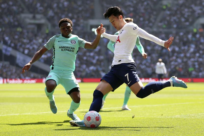 Tariq Lamptey dari Brighton and Hove Albion (kiri) dan Son Heung-min dari Tottenham Hotspur berebut bola dalam pertandingan sepak bola Liga Inggris di Stadion Tottenham Hotspur, London, Sabtu (16/4/2022).. 