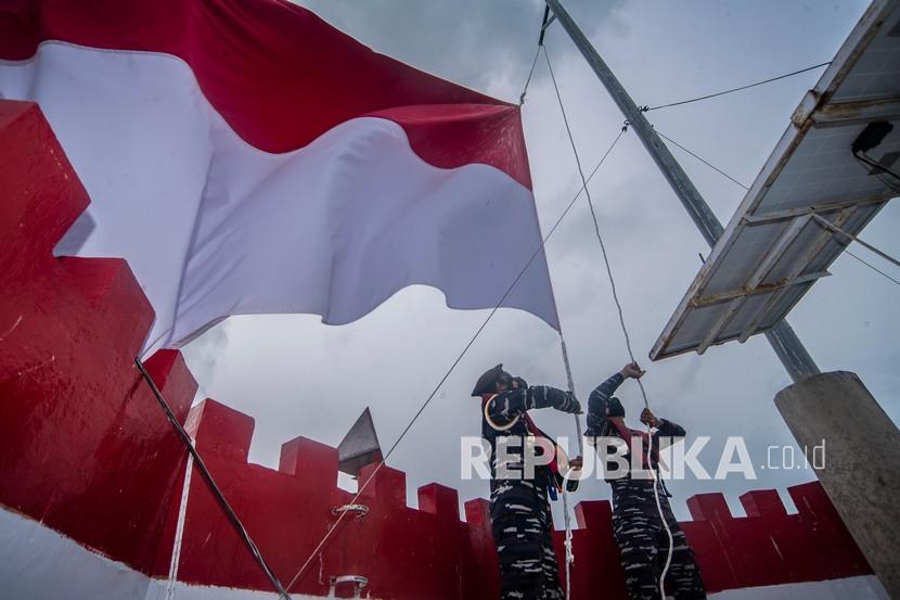 Taruna Akademi Angkatan Laut (AAL) Tingkat III Angkatan ke-68 mengibarkan bendera merah putih di atas Mercusuar Karang Unarang, Perairan Ambang Batas Laut (Ambalat), Nunukan, Kalimantan Utara, Senin (13/9/2021). Indonesia didorong menegaskan posisinya yang menganut politik bebas aktif. 