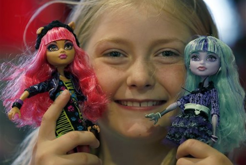 Seorang anak berpose dengan boneka produksi Mattel miliknya (ilustrasi). Meski menaikkan harga, penjualan produk mainan Mattel tidak mengalami tekanan.
