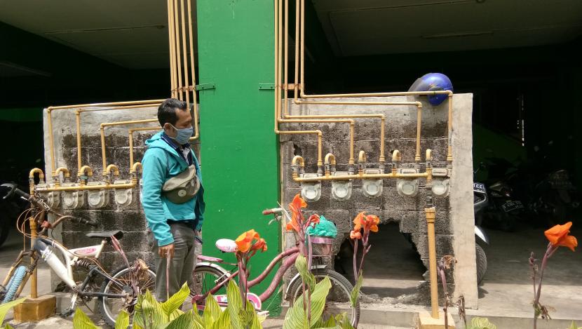 Teguh, penghuni Rusunawa Griya Tipar Cakung berada di depan instalasi jaringan gas bumi pada Sabtu (29/8).