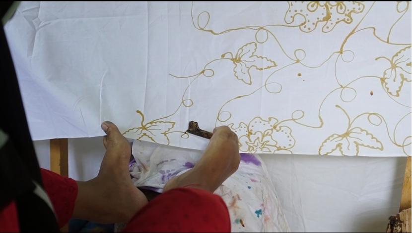 Teknik batik menggunakan kaki yang dilakukan oleh salah satu penyandang disabilitas sekaligus seniman batik Tanah Air, Trimah.