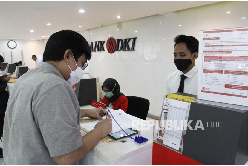 Teller Bank DKI tengah melayani nasabah dengan protokol pencegahan penyebaran covid-19 di kantor layanan Bank DKI di Jakarta. Bank DKI menyiapkan tiga langkah untuk memberikan keringanan atau merelaksasi kredit yang diambil pelaku Usaha Mikro Kecil dan Menengah (UMKM) di tengah krisis ekonomi akibat pandemi COVID-19.