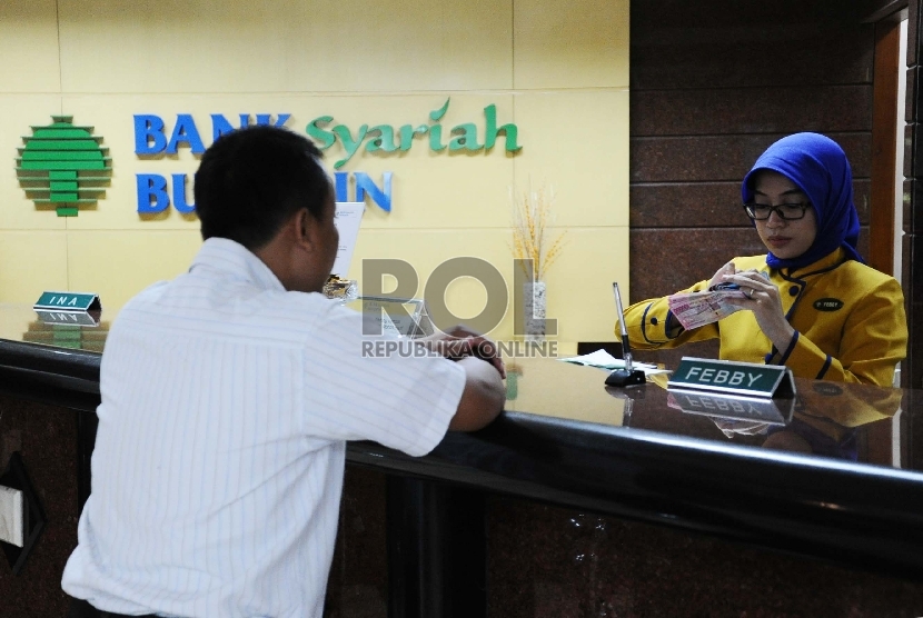  Teller melakukan aktifitas di kantor Bank Syariah Bukopin, Jakarta, Selasa (6/10). 