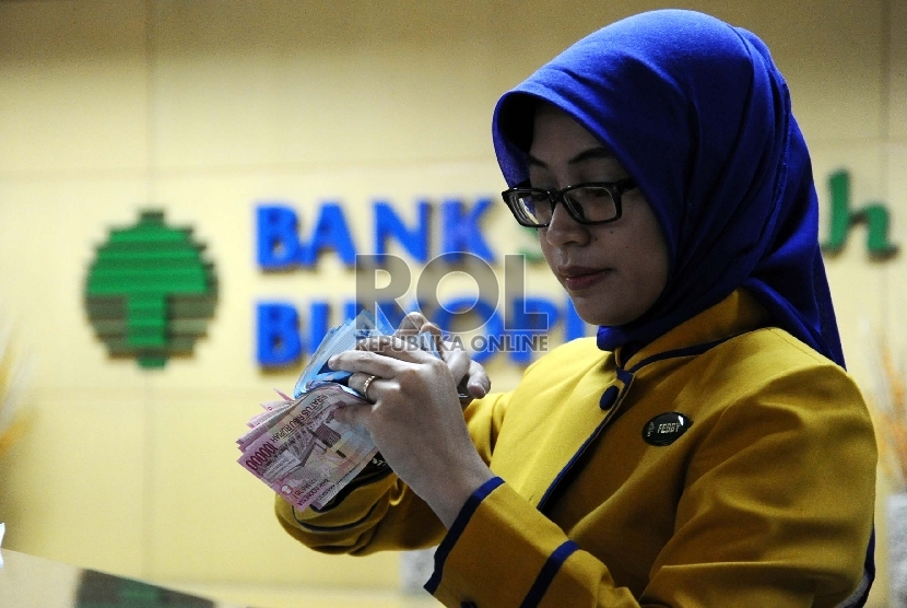  Teller melakukan aktifitas di kantor Bank Syariah Bukopin, Jakarta, Selasa (6/10).