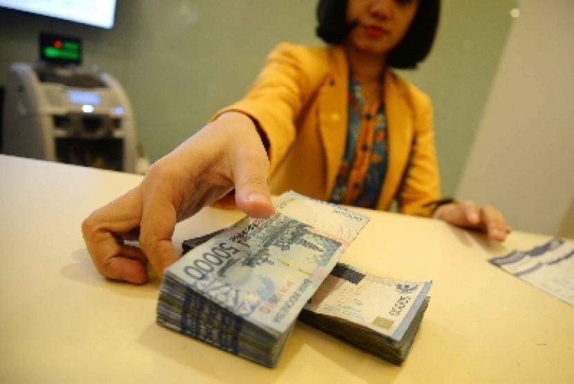 Teller melakukan transaksi dengan nasabah di Banking Hall Bank Mandiri, Jakarta, Rabu (11/3).