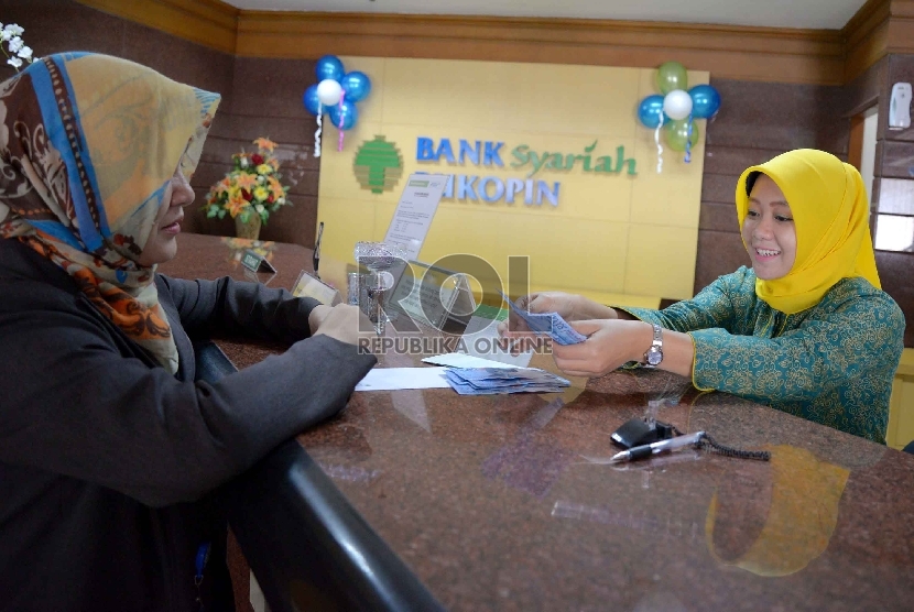  Teller melayani nasabah di kantor Bank Syariah Bukopin (BSB) di Jakarta, Rabu (21/1).  ( Republika/ Yasin Habibi)
