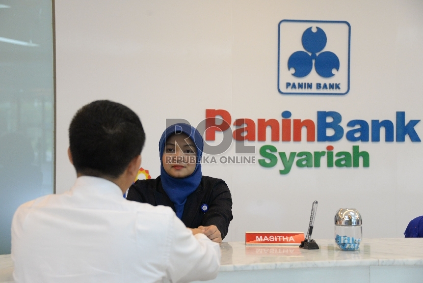 Teller melayani nasabah di salah satu banking hall Panin Bank Syariah. Jakarta, Senin (18/5).