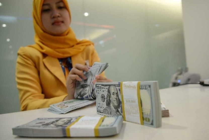 Teller menghitung mata uang dolar AS di Banking Hall Bank Mandiri, Jakarta, Rabu (11/3).