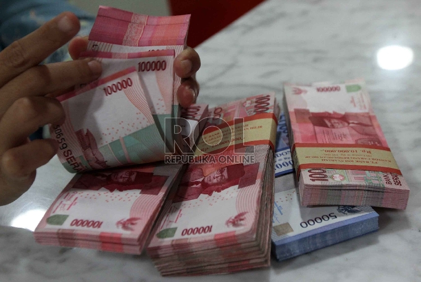 Teller menghitung rupiah di banking hall sebuah bank di Jakarta, Selasa (20/1).  (Republika/ Yasin Habibi)