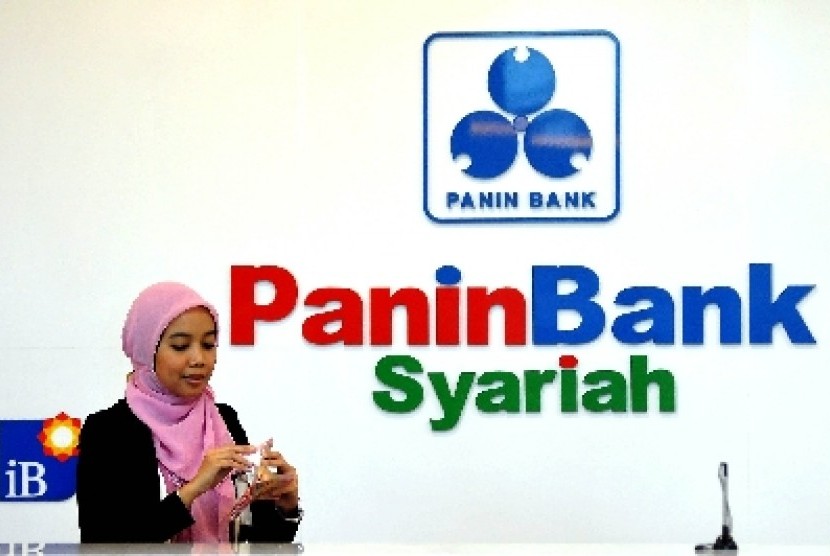 Teller menghitung uang nasabah di salah satu banking hall Panin Bank Syariah. Jakarta, Selasa (2/9).