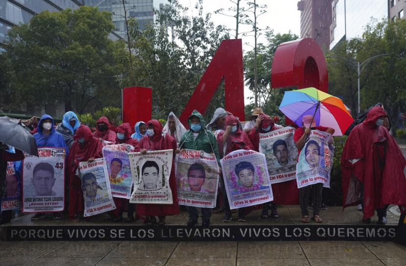Teman dan kerabat mencari keadilan untuk 43 mahasiswa Ayotzinapa yang hilang berkumpul di sekitar monumen yang didedikasikan untuk para mahasiswa selama demonstrasi di Mexico City, Jumat, 26 Agustus 2022. Enam dari 43 mahasiswa yang 