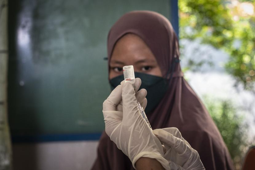 Tenaga kesehatan bersiap menyuntikkan vaksin COVID-19 kepada warga di Jakarta, Jumat (17/12). Organisasi Kesehatan Dunia (WHO) memperingatkan varian omicron menyebar lebih cepat daripada varian Delta.