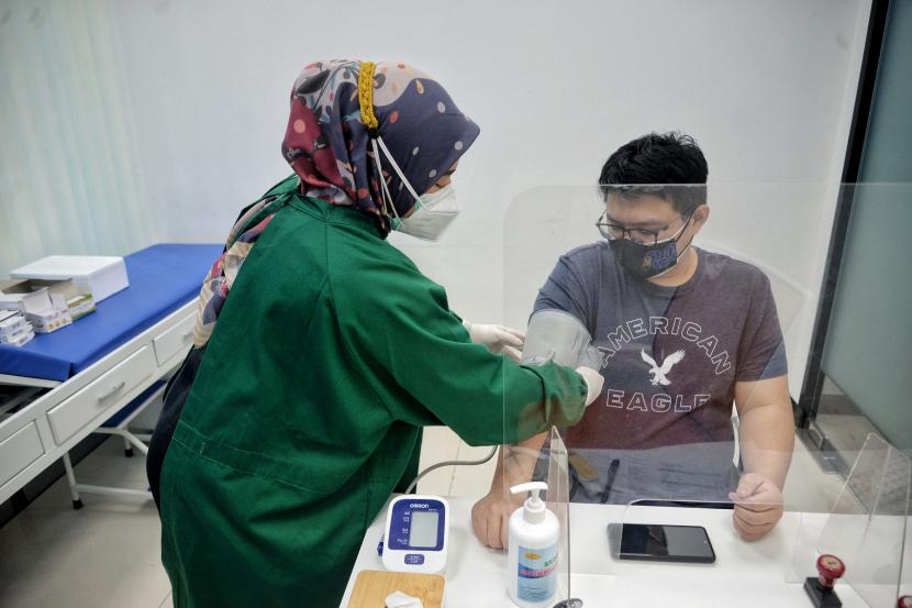 Tenaga kesehatan memeriksa kesehatan warga sebelum menyuntikan vaksin booster atau vaksin penguat jenis sinopharm di Klinik Kimia Farma, Jalan Radio Dalam, Jakarta.