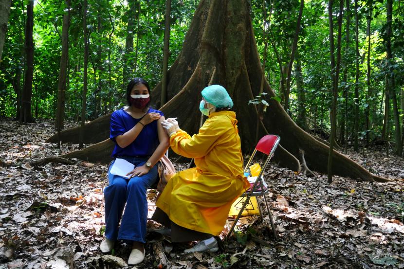 Tenaga kesehatan menyuntik vaksin Covid-19 mahasiswa saat vaksinasi Covid-19 massal di Hutan Laboratorium Fakultas Kehutanan UGM, Yogyakarta.