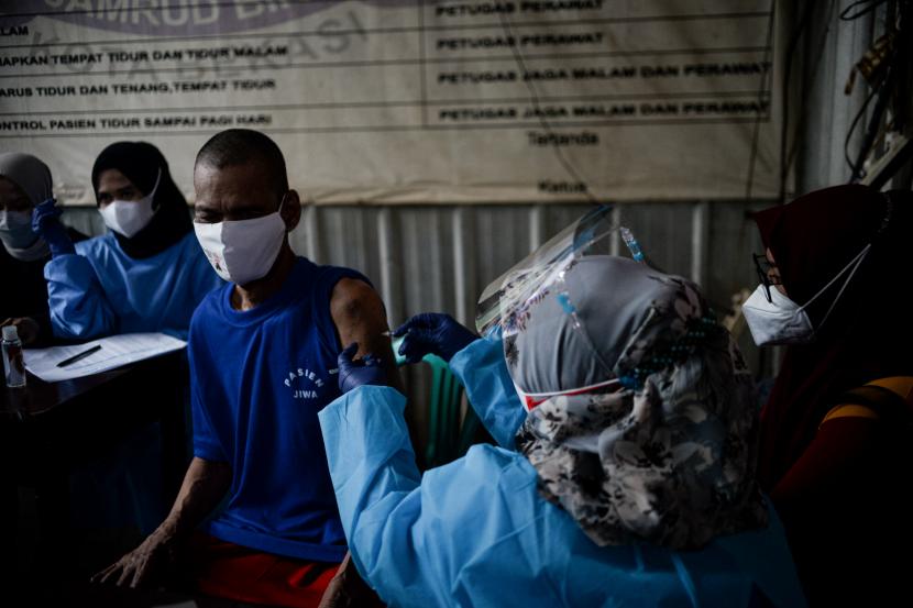 Tenaga kesehatan menyuntikan vaksin Covid-19 AstraZeneca kepada warga binaan Orang Dalam Gangguan Jiwa (ODGJ) di Yayasan Jambrud Biru, Kota Bekasi, Jawa Barat.