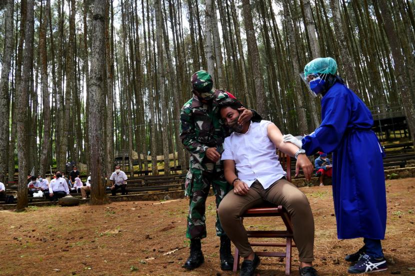 Tenaga kesehatan menyuntin vaksin Sinovac untuk pelaku wisata di kawasan wisata Hutan Pinus Mangunan, Bantul Yogyakarta.