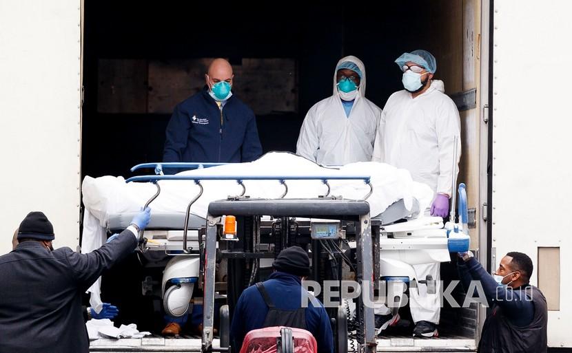 Tenaga medis dan karyawan rumah sakit memindahkan mayat ke tempat penyimpanan sementara di kamar mayat di Pusat Rumah Sakit Brooklyn di Brooklyn, New York, AS, Senin (30/3).