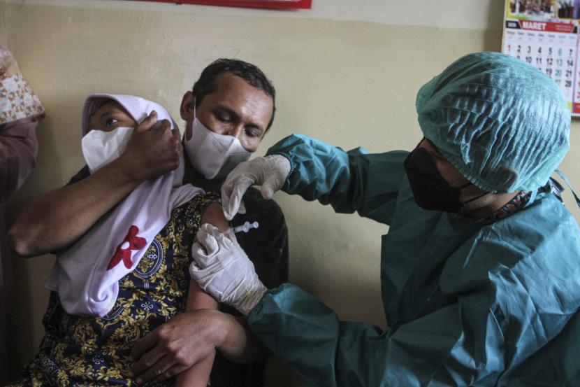 Tenaga medis menyuntikan vaksin COVID-19 kepada siswa SLB di SLB BC Manunggal Bhakti, Depok, Jawa Barat, Selasa (11/1/2022). Pemerintah Kota Depok melakukan percepatan vaksin bagi anak usia 6-11 tahun sebagai upaya mengejar Pembelajaran Tatap Muka (PTM) 100 persen di sekolah.