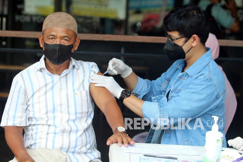 Tenaga medis menyuntikkan vaksin kepada warga saat giat vaksinasi di kawasan pusat perdagangan di Jalan Gajahmada, Pontianak, Kalimantan Barat, Senin (27/9). Vaksinasi ditargetkan selesai seluruhnya pada 2022